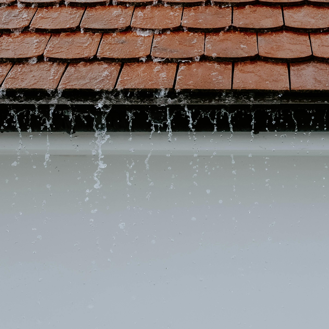 Roof with water pouring over guttering